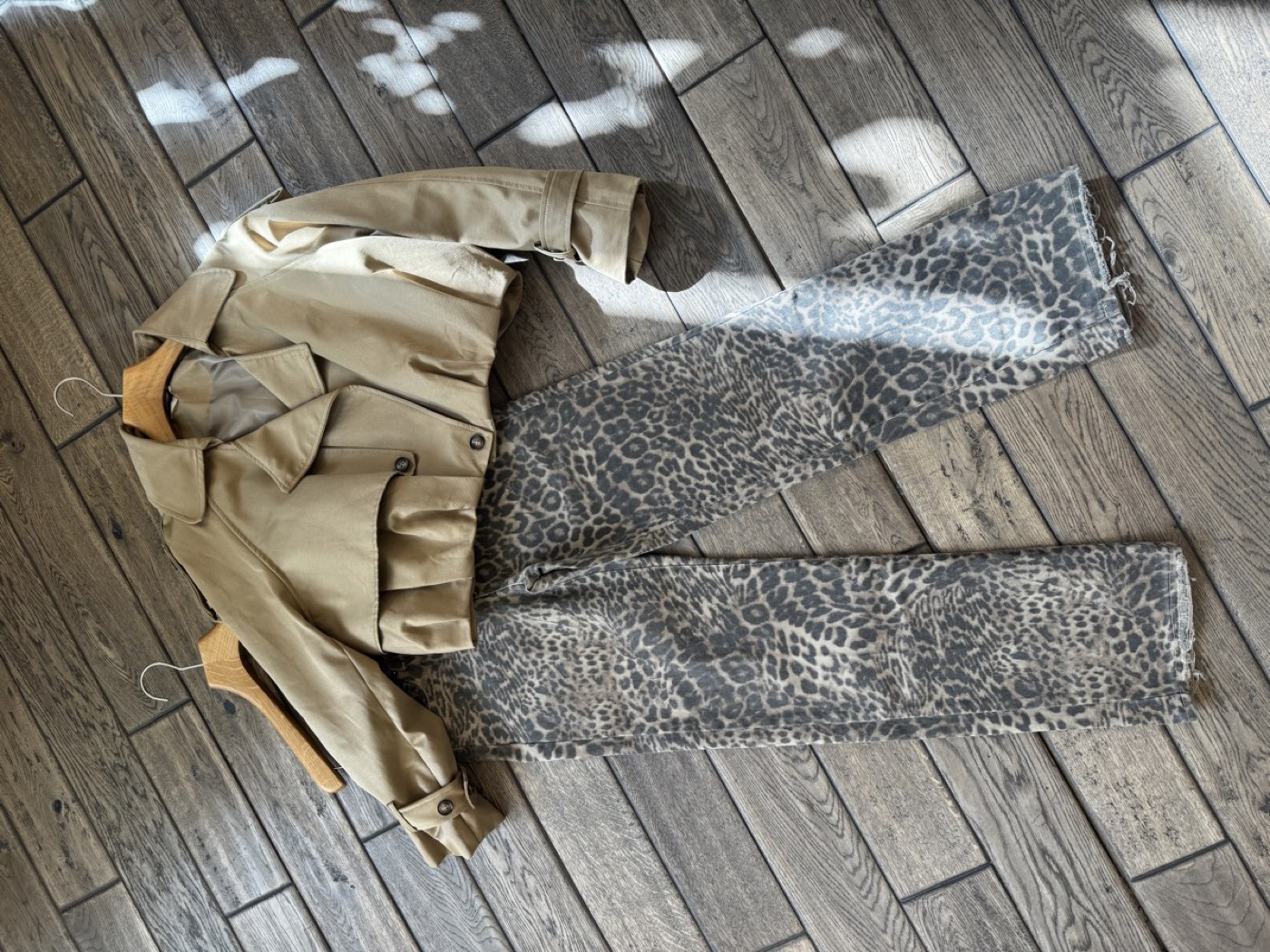 Outfit-Kombination aus kurzem Trenchcoat und gemusterter Hose